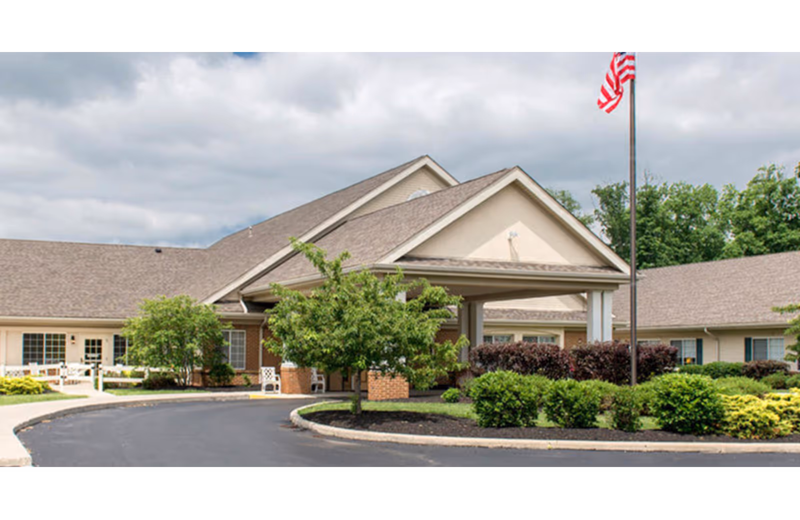 Exterior view of Legacy Marion senior living facility with entrance, driveway, flagpole, and landscaping.