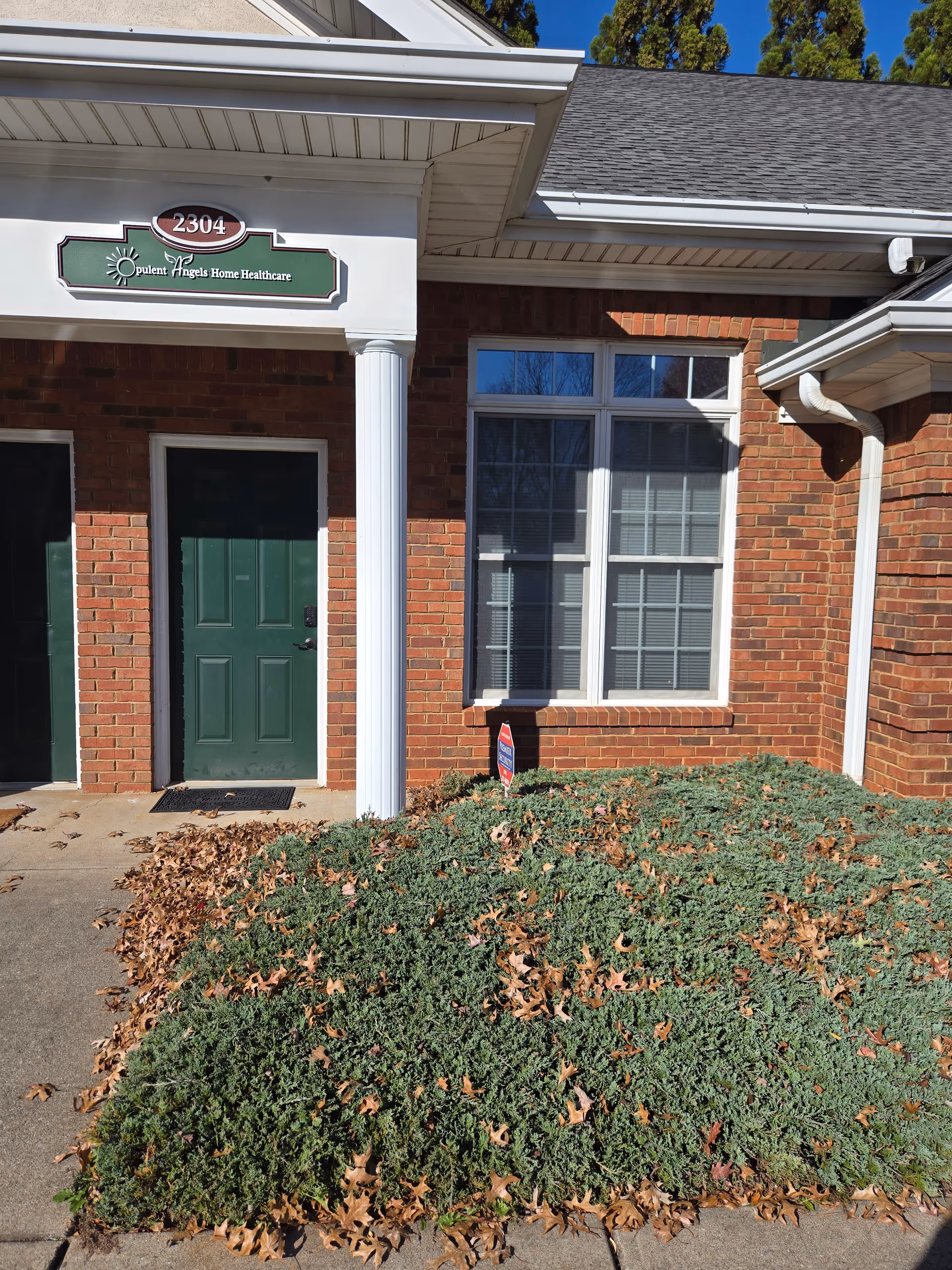 Front entrance of Opulent Angels senior facility with brick facade and sign.