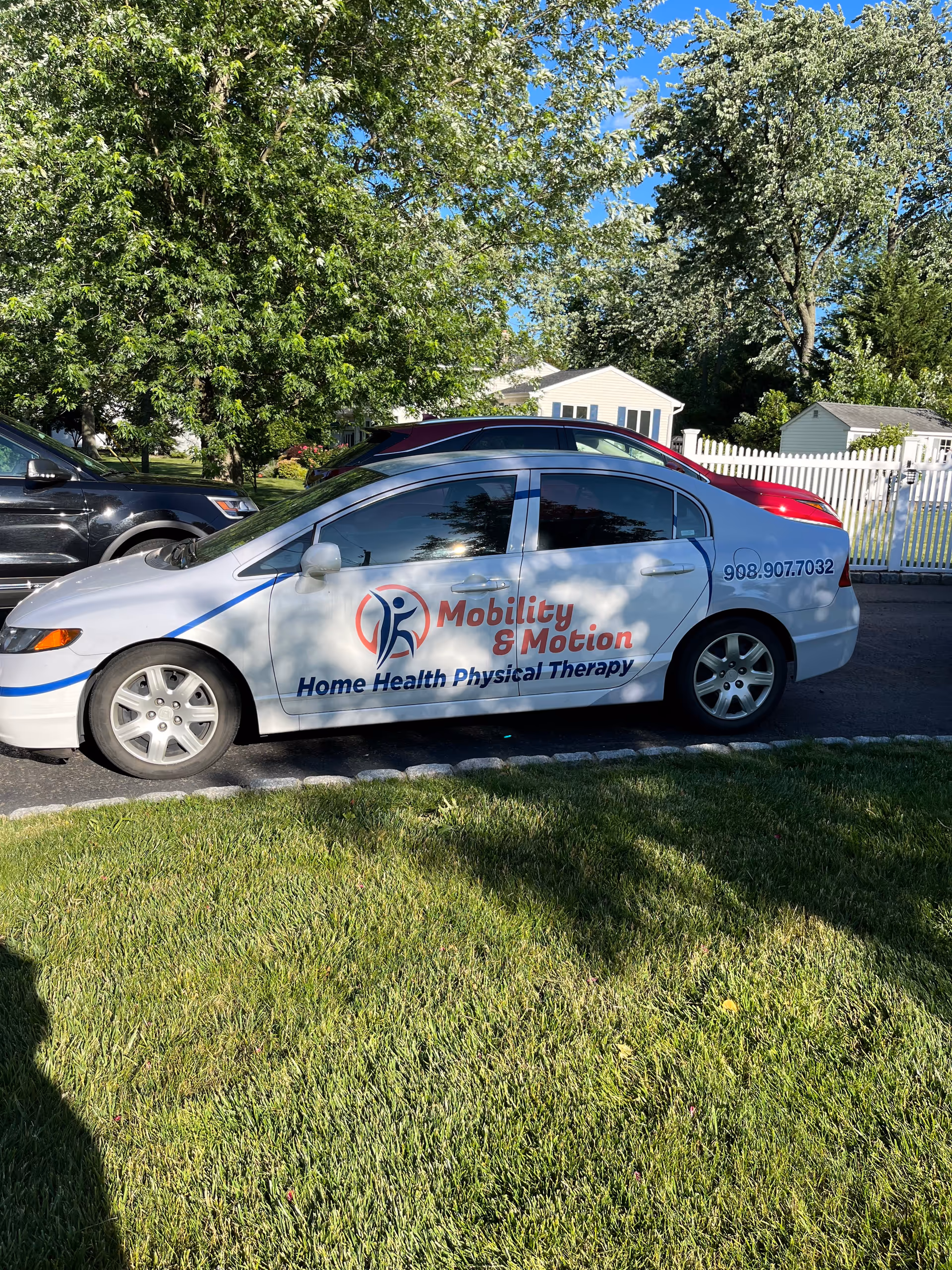 White Mobility and Motion van with Home Health Physical Therapy logo parked along a suburban street
