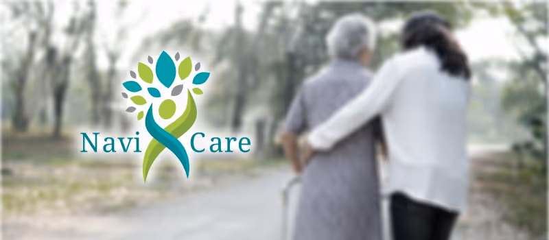 Two people walk on a tree-lined outdoor path beside the Navi-Care logo.