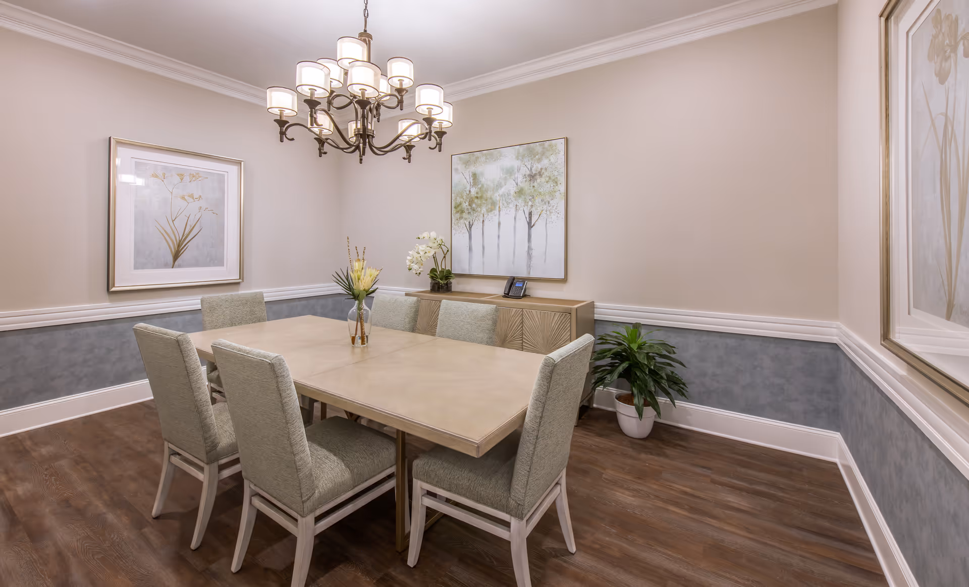 A formal dining room with a wooden table, upholstered chairs, and a chandelier.
