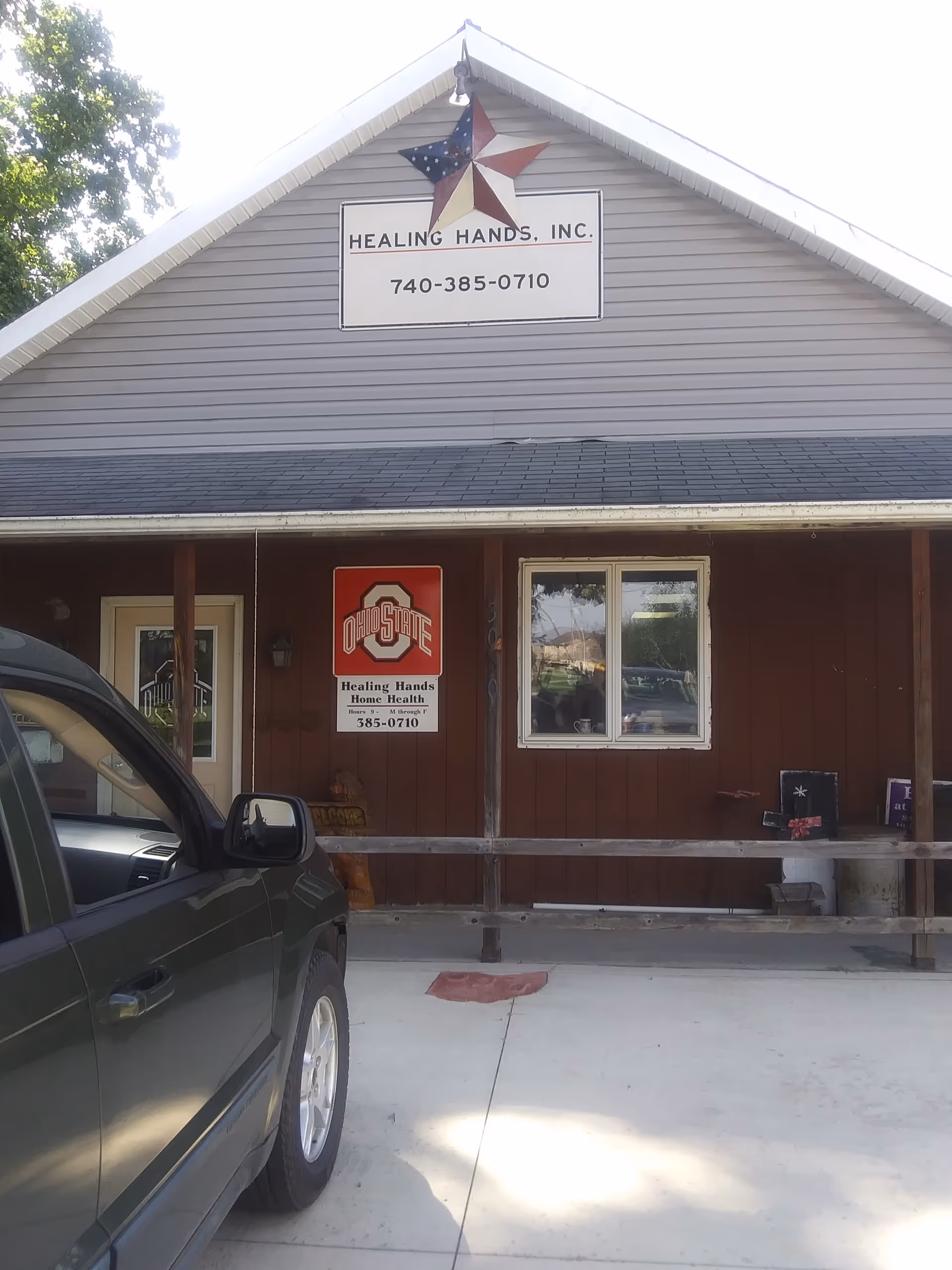 Front view of Healing Hands Home Health building with sign, star logo, and parked car.