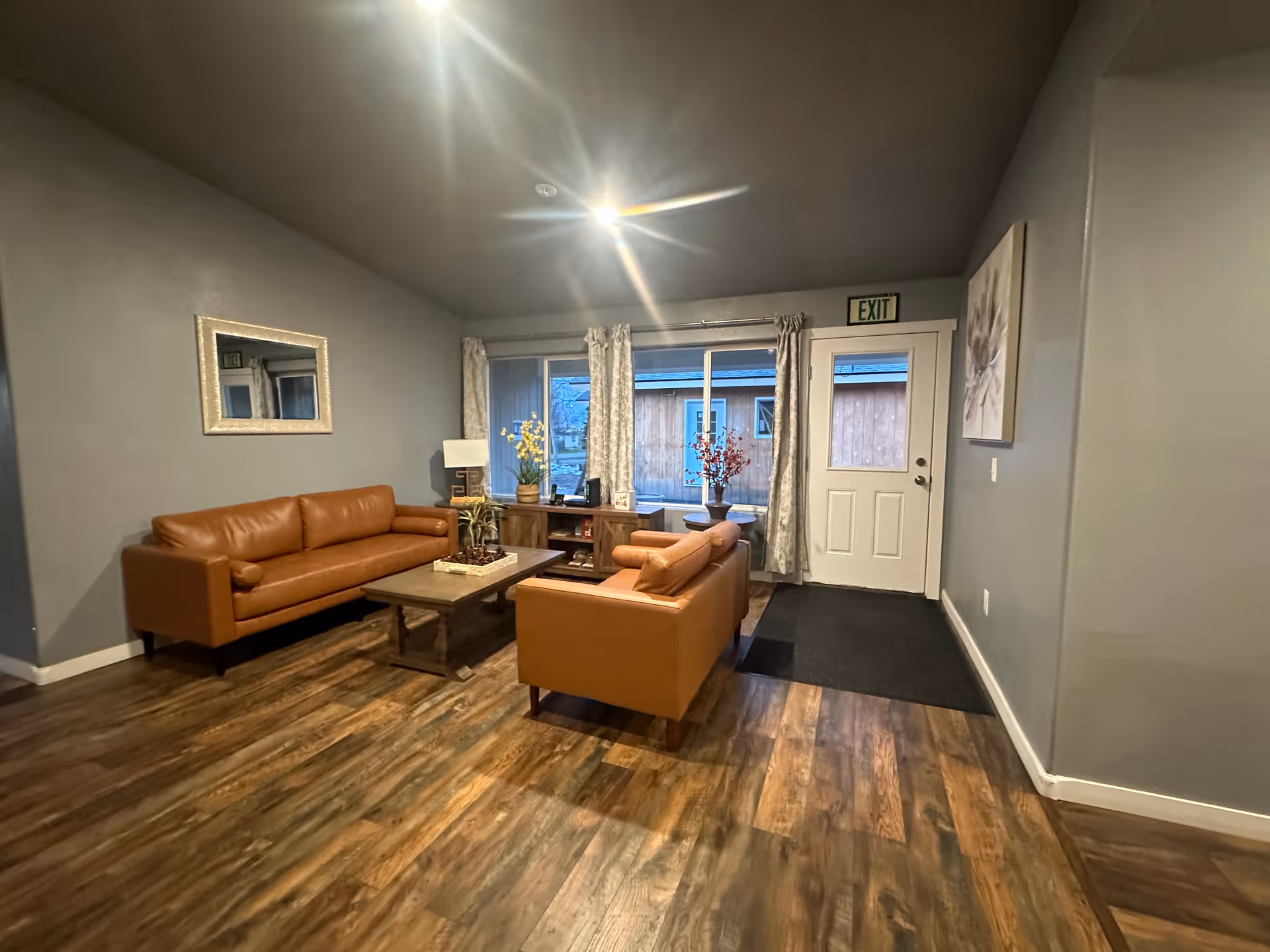 Cozy living room in a senior facility with brown leather sofas and coffee table.