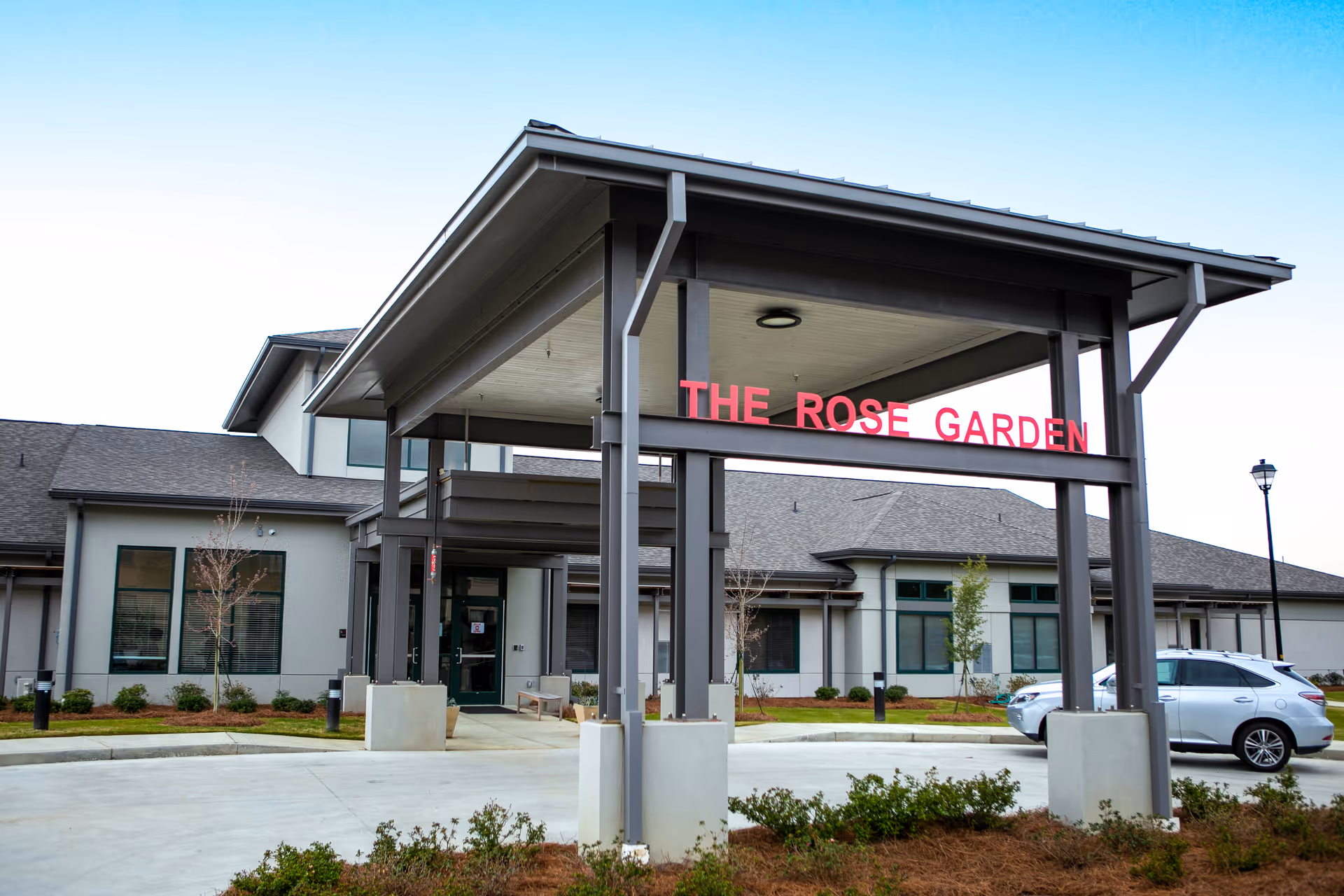 Exterior view of a senior living facility entrance with a covered porte-cochère.