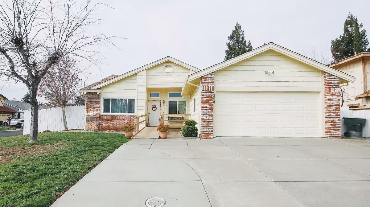 Front view of a beige, brick-accented house with a two-car garage.