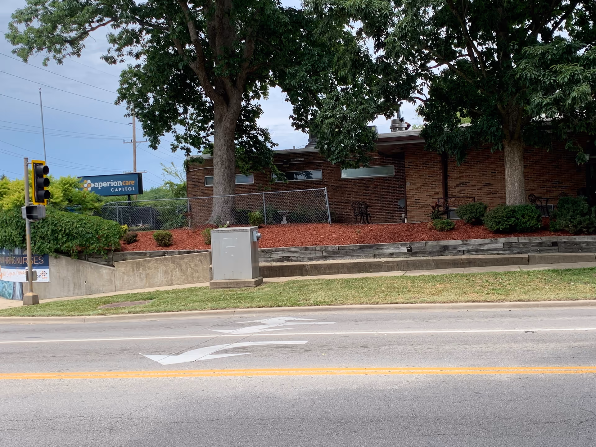 Exterior view of Arcadia Care on the Hill with brick building, trees, and street in foreground.