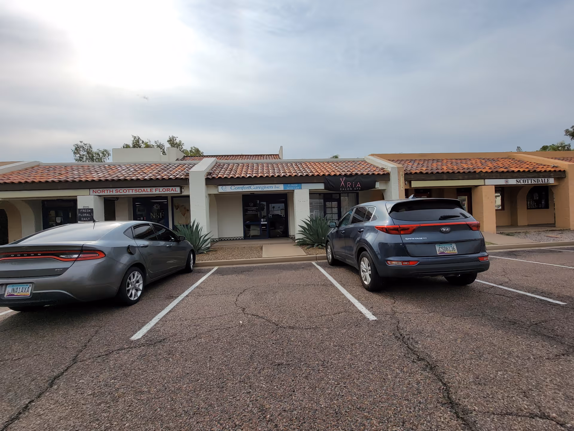 Parking lot in front of a strip plaza storefront labeled Comfort Caregivers.