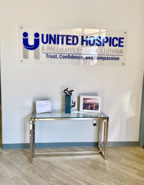Interior wall features a United Hospice & Palliative Care of Arizona sign above a console table.