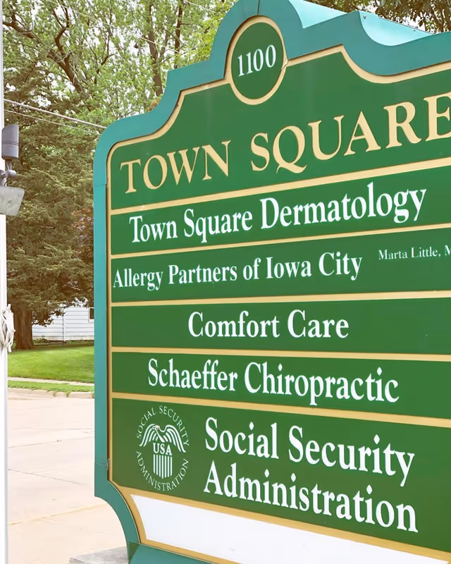 Green outdoor signboard lists tenants such as Comfort Care, dermatology, chiropractic, SSA.