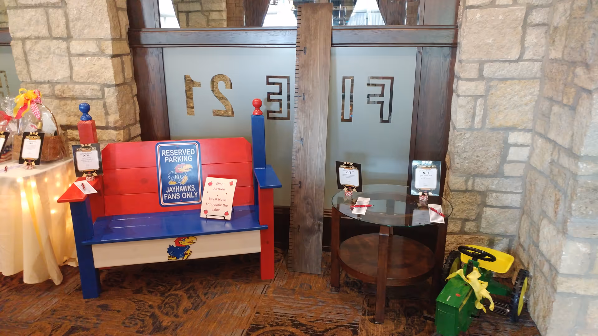 Colorful interior lobby featuring a blue-red bench, small round table, and stone-walled decor.