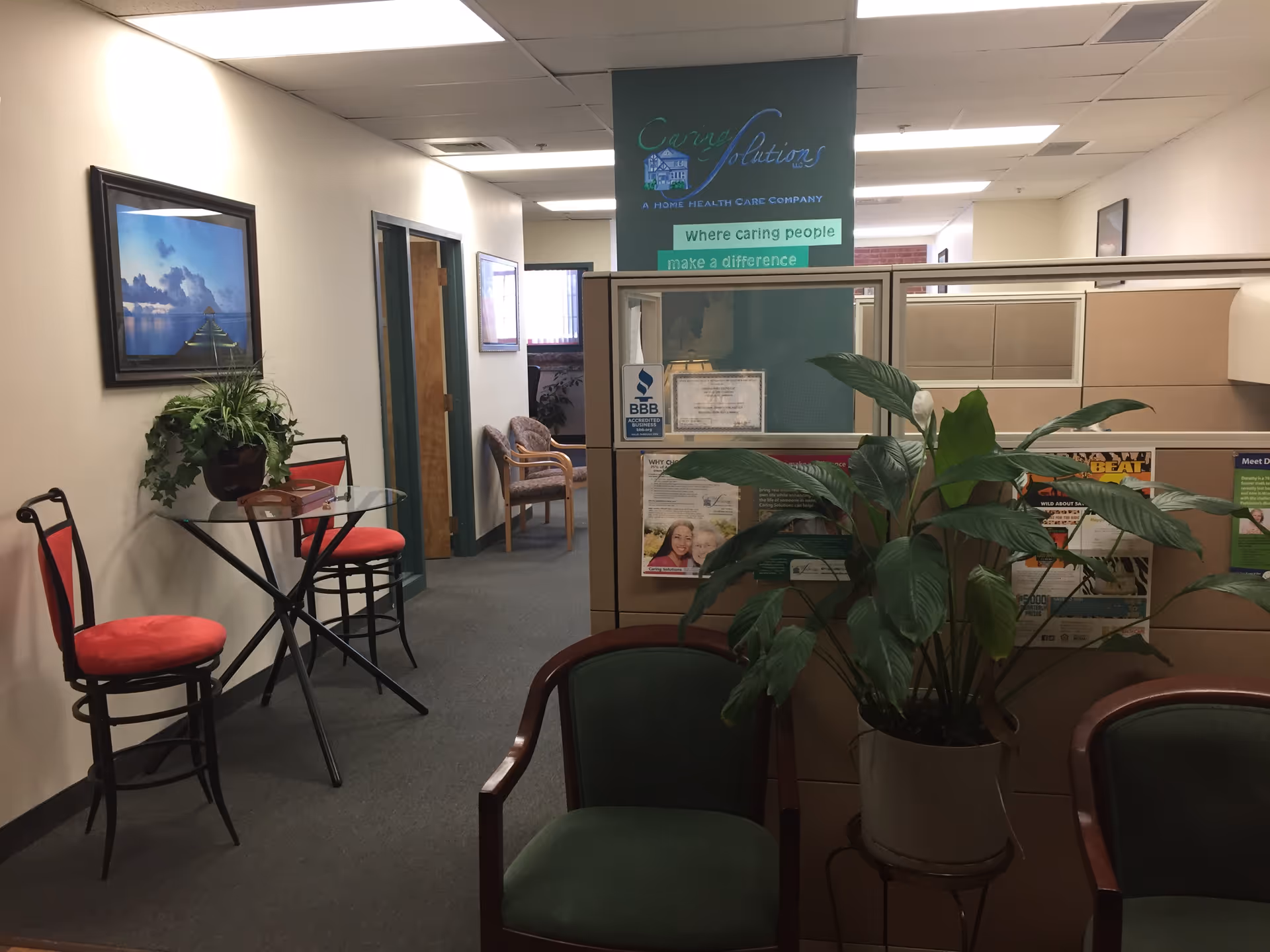 Interior reception area with seating, plants, and cubicles in Caring Solutions LLC.