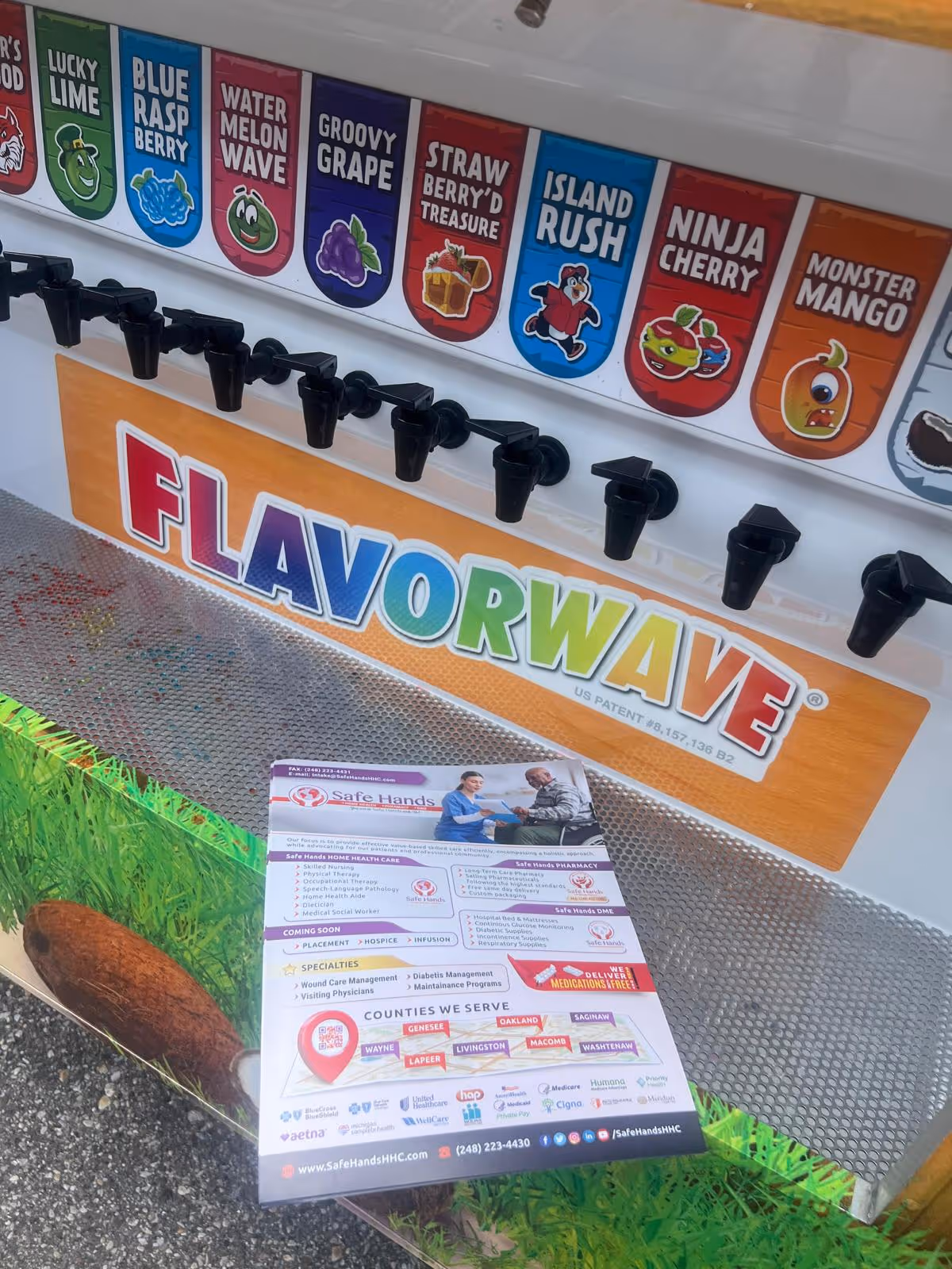 Close-up of FlavorWave beverage dispenser with flavor labels and Safe Hands flyer
