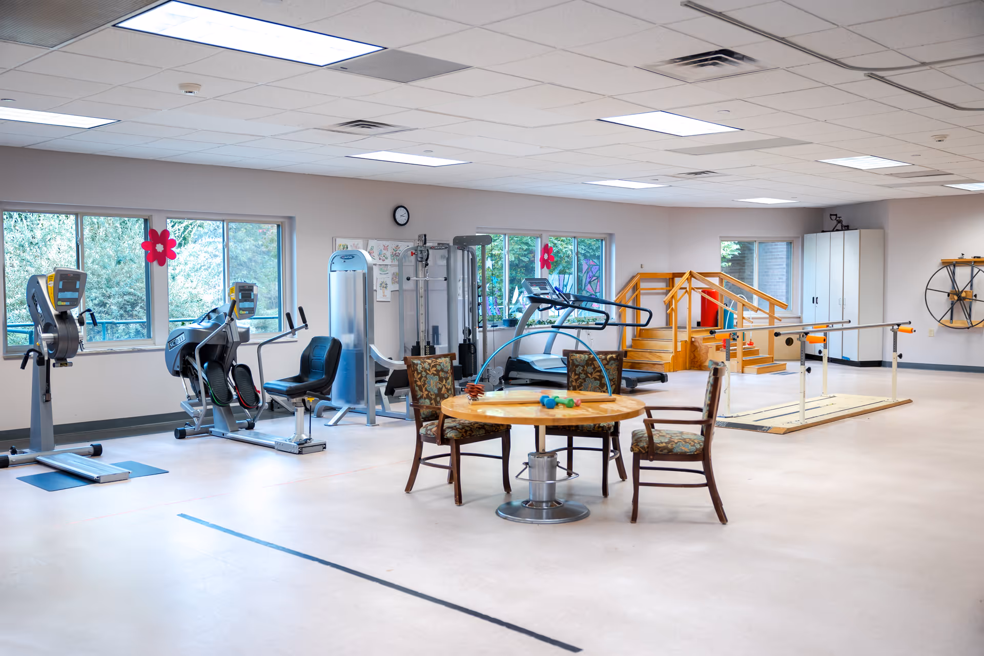 Interior fitness area in River Ridge Living Center with exercise machines and seating.
