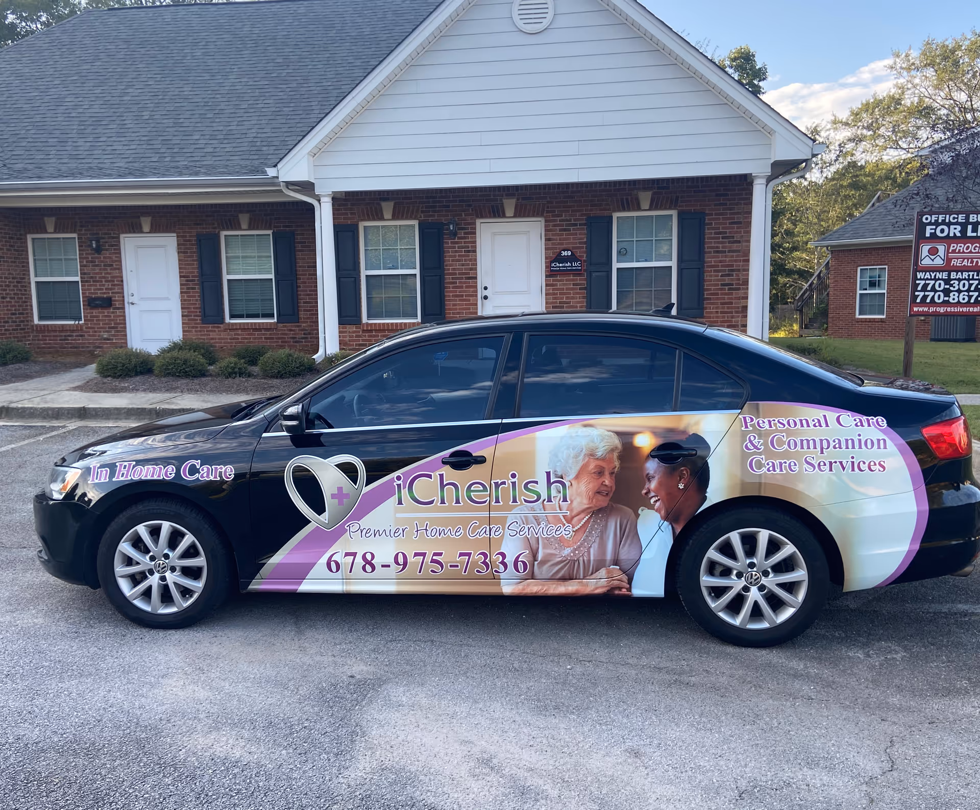 Wrapped black sedan advertising iCherish in front of a brick senior care facility.