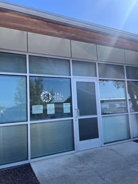 Glass storefront entrance to S & S Health Care facility with logo on door.