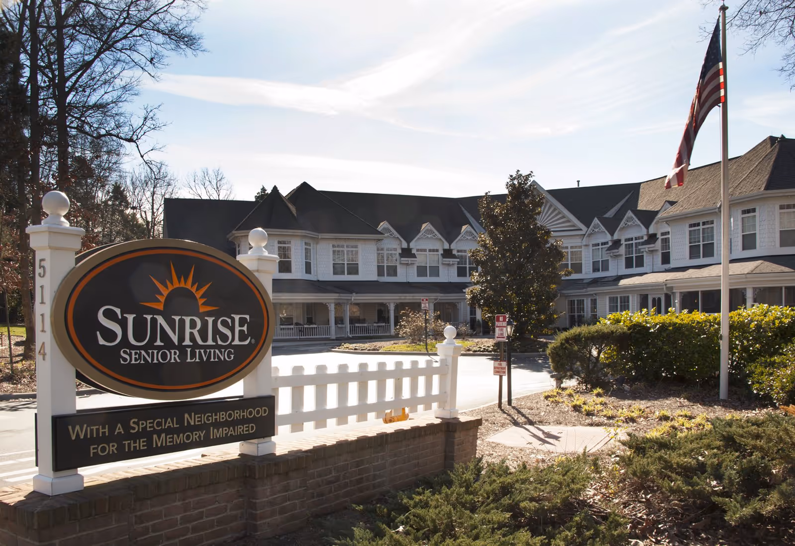 Sunrise Senior Living facility exterior with sign and flag at entrance.