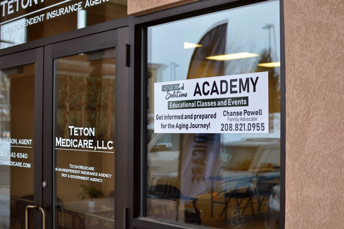 Exterior entrance with glass doors displaying Academy and Senior Solutions signs.