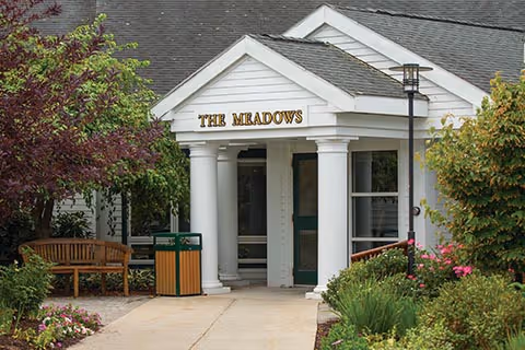 Front entrance of The Meadows Health Center at Edgewood with white columns and landscaping.