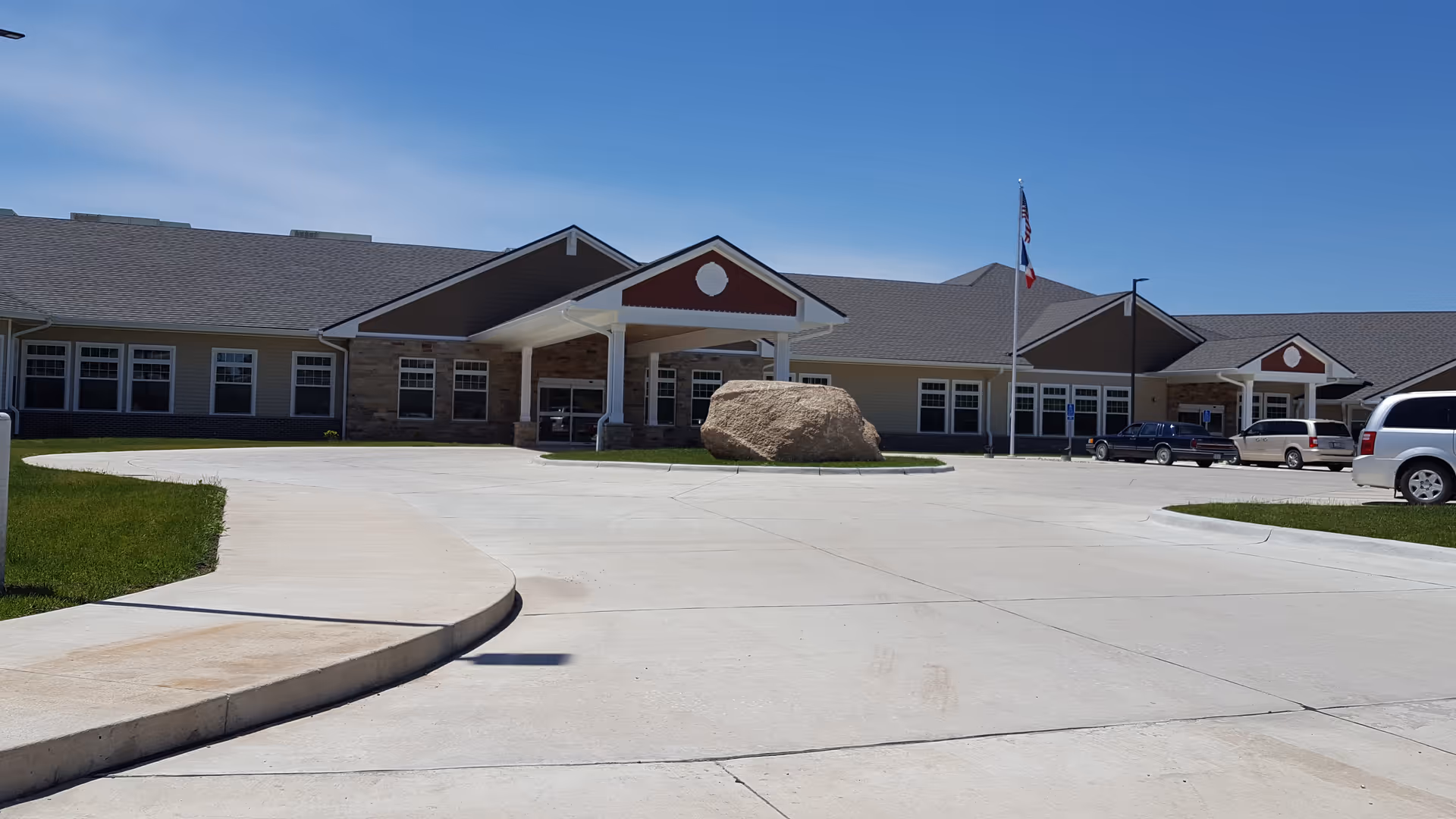 Exterior view of Exira Care Center front entrance with a large rock centerpiece