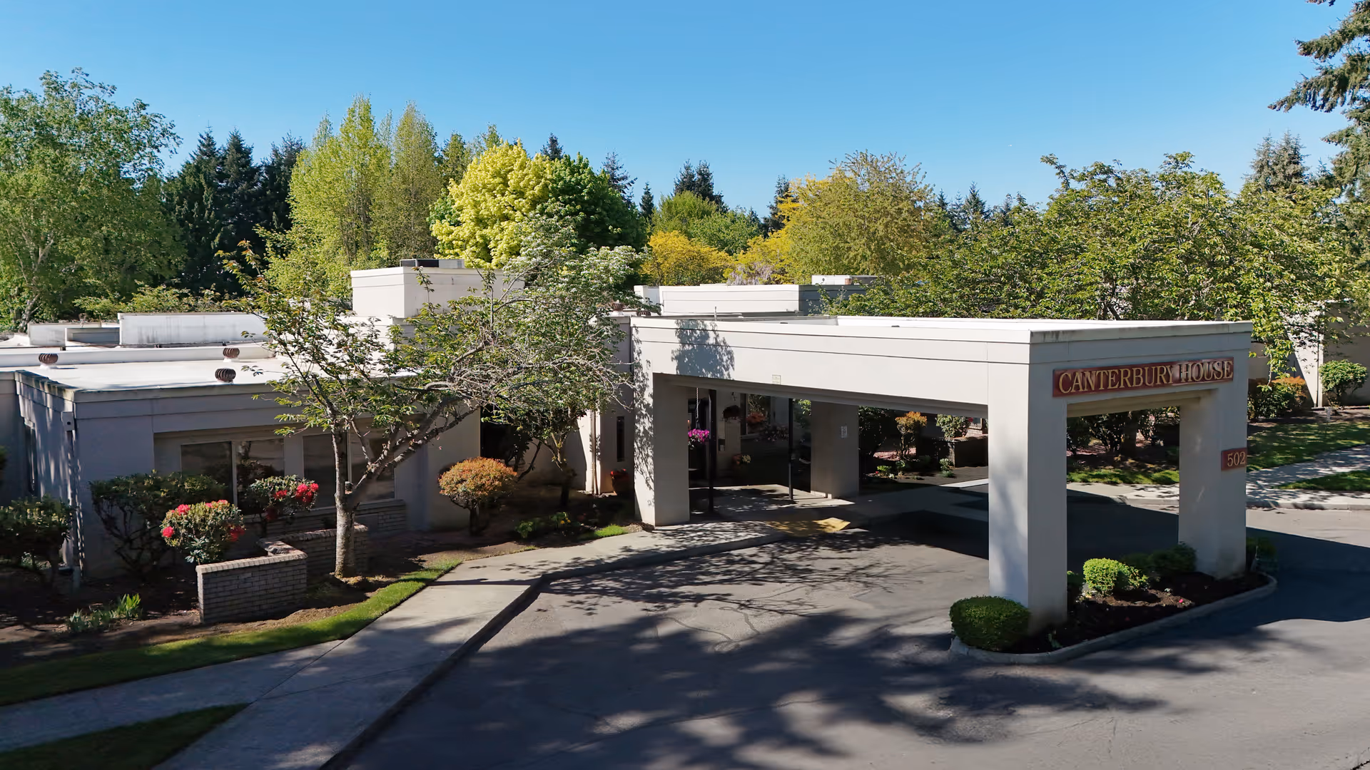 Exterior view of Canterbury House senior living facility with a covered entrance.