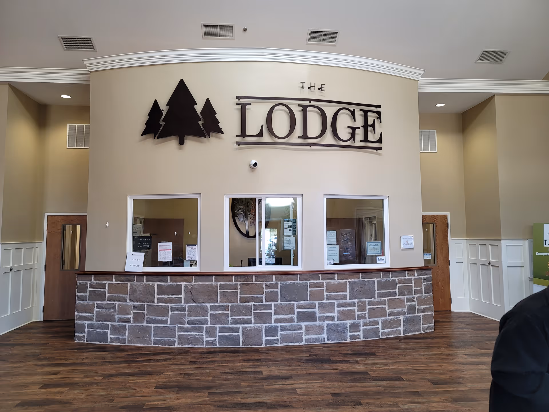 Interior lobby with a curved reception desk and 'The Lodge' sign.