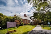 Exterior view of The Village at St. Barnabas, brick building with lawn and path