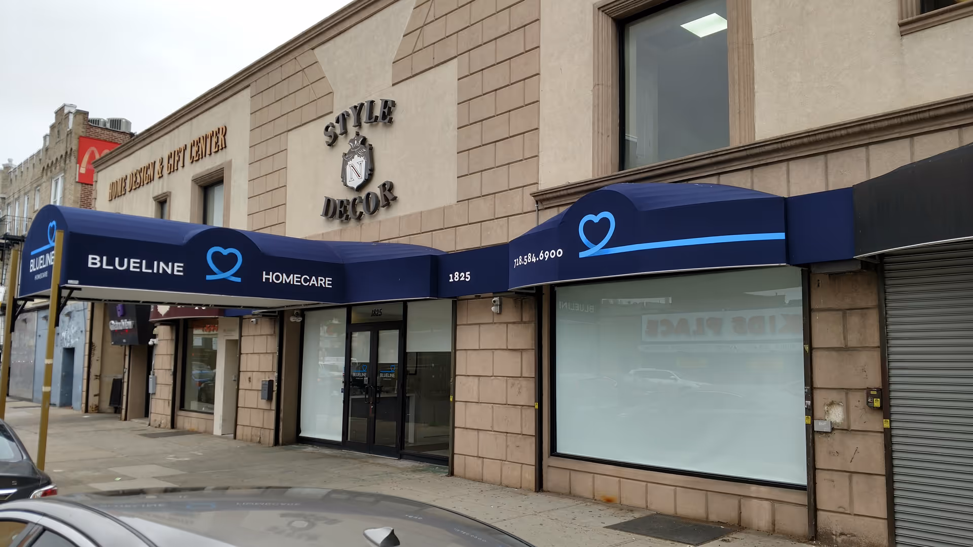 BlueLine HomeCare storefront with a blue awning and heart logo along a brick building.
