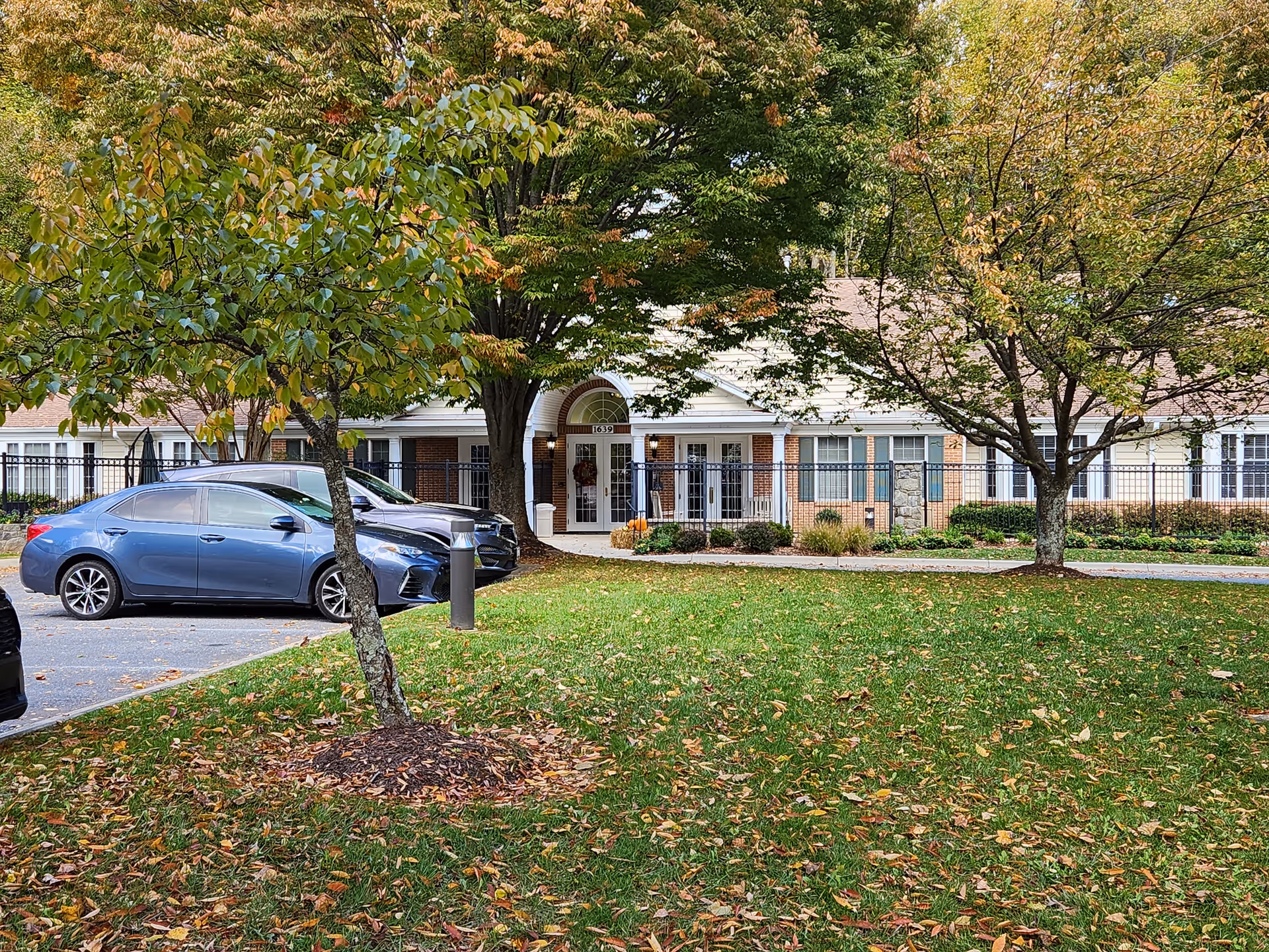 Exterior view of Meadows 1639 facility with entrance, trees, and parked cars along the front.