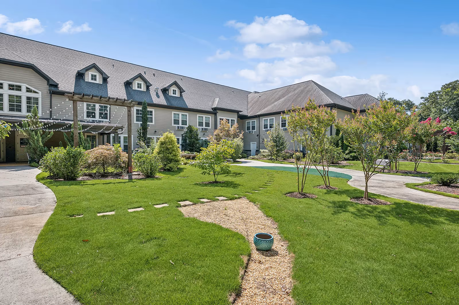 The Phoenix at Tucker exterior: modern building with manicured lawn, walking paths, and string lights.