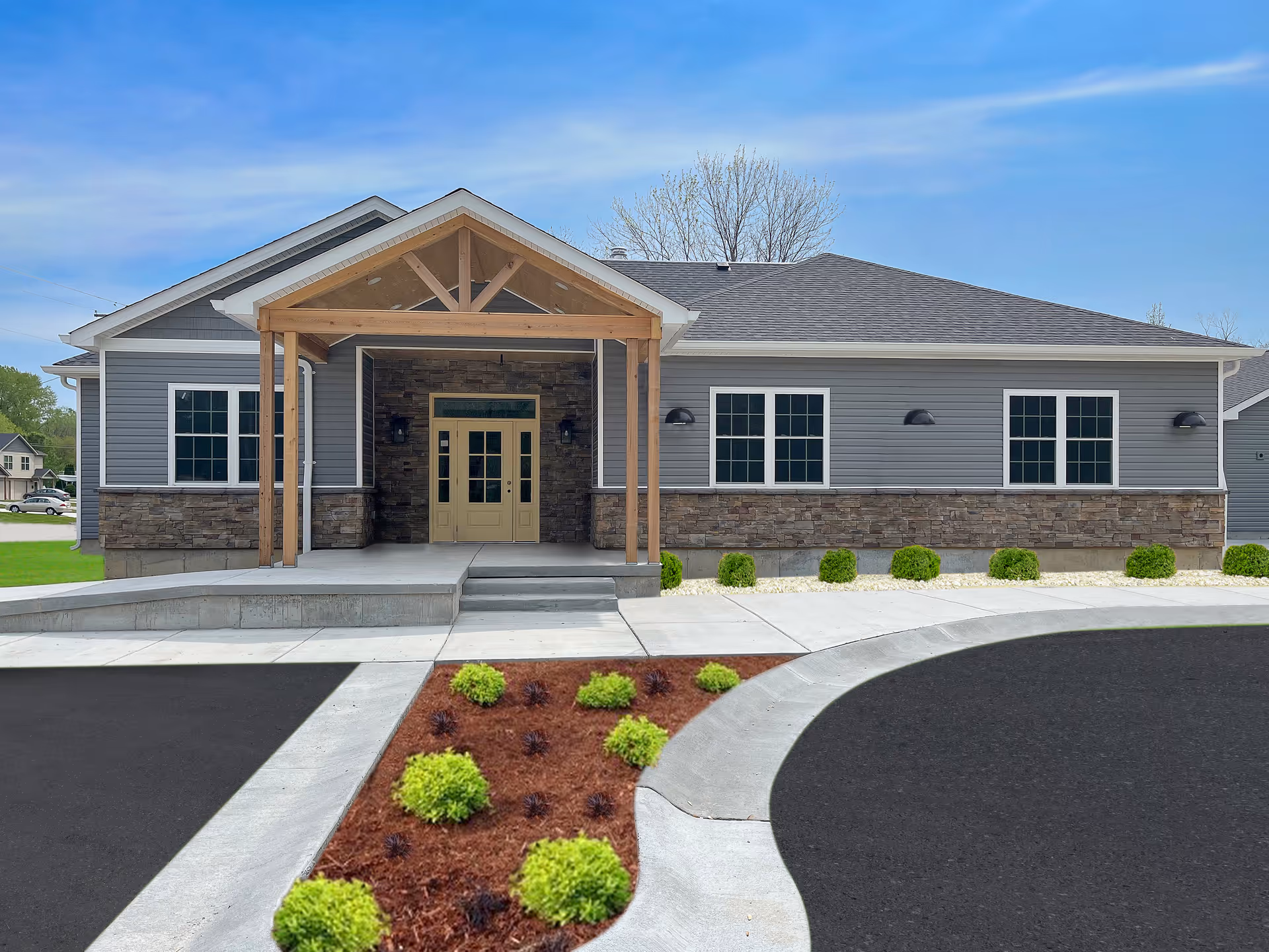 A modern single-story senior living facility with stone accents and a wooden covered entry.