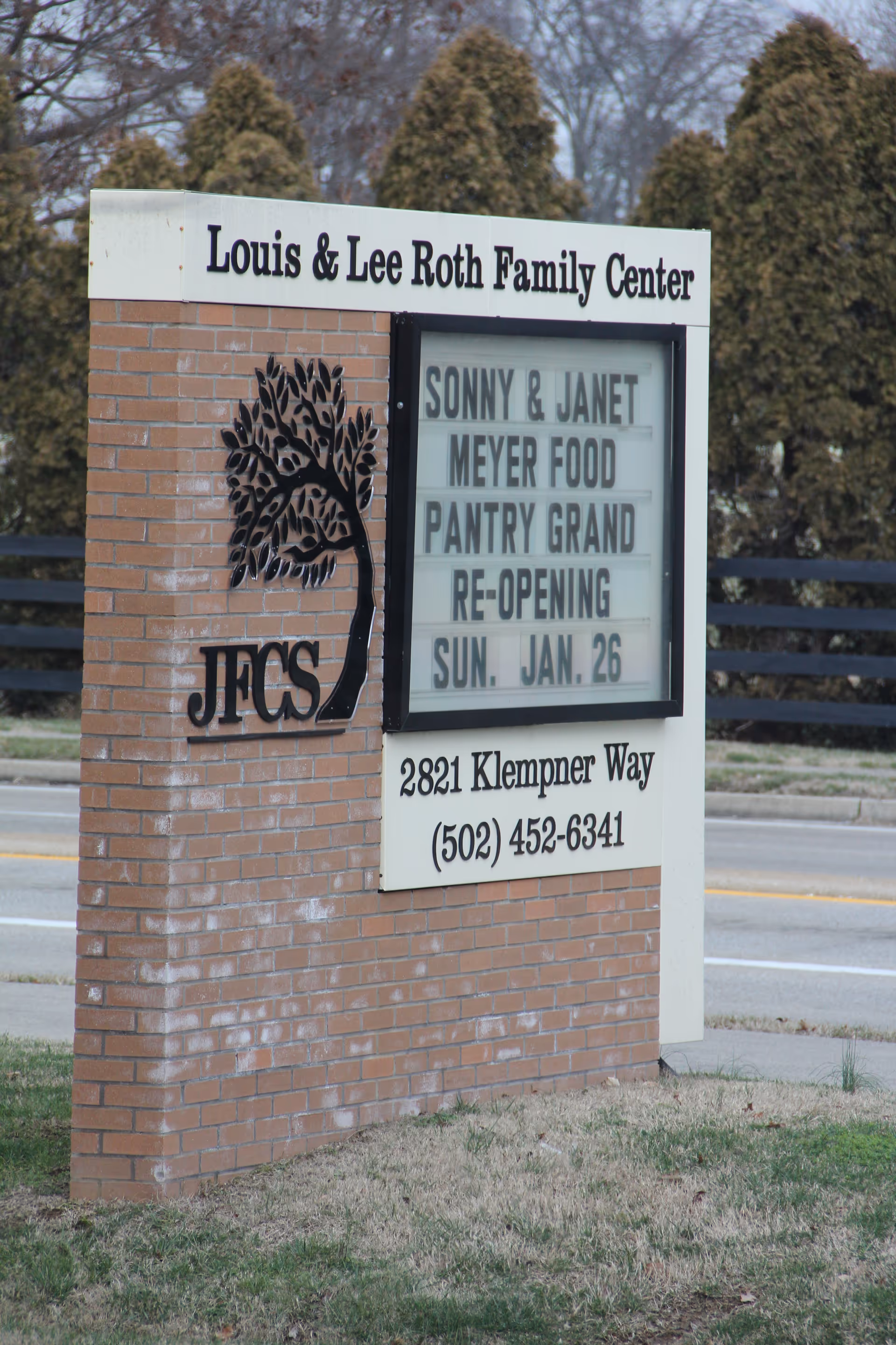 Brick sign reads Louis & Lee Roth Family Center beside a road.