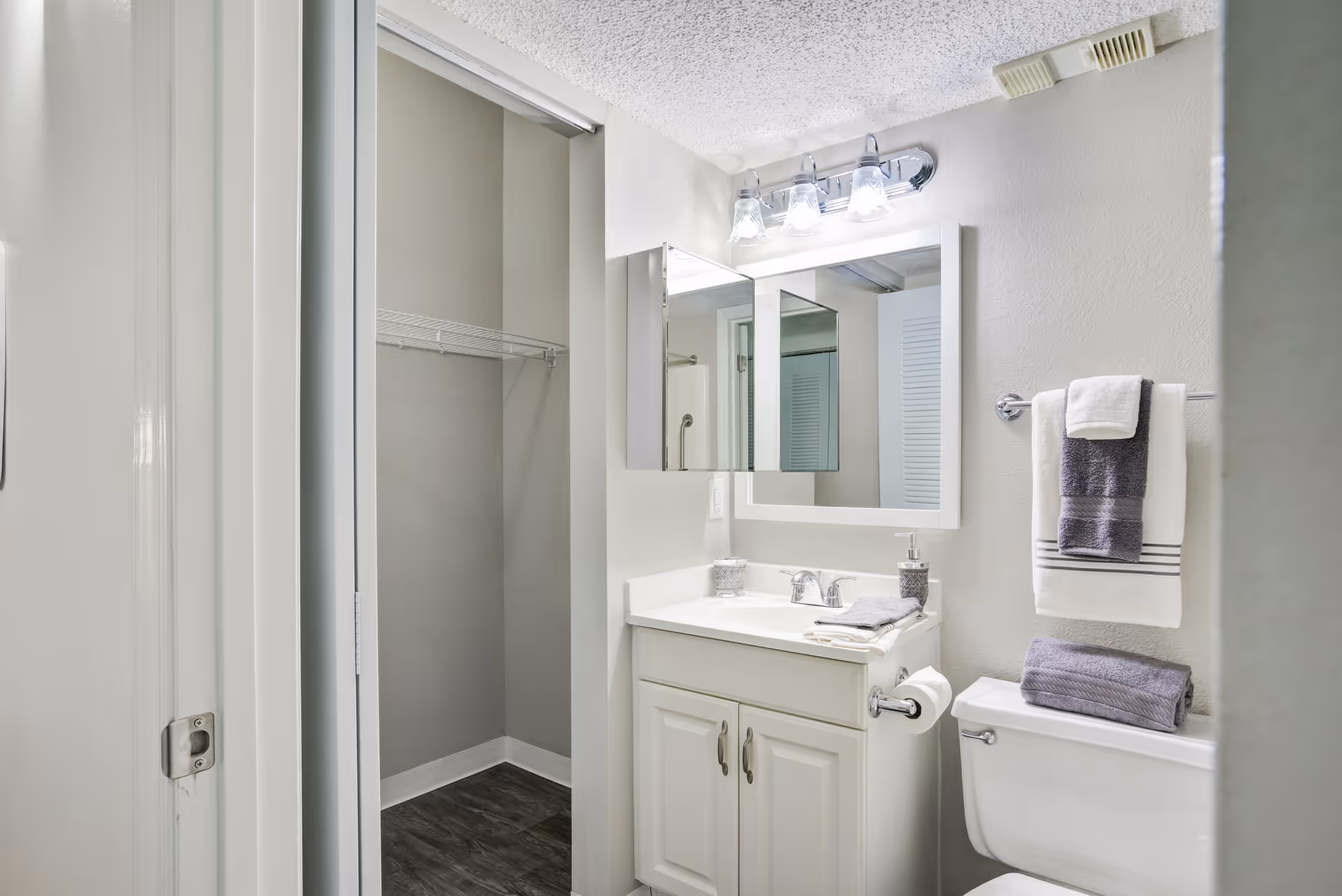 Small bathroom with sink, mirror, towel rack, and shower stall in a senior living facility.