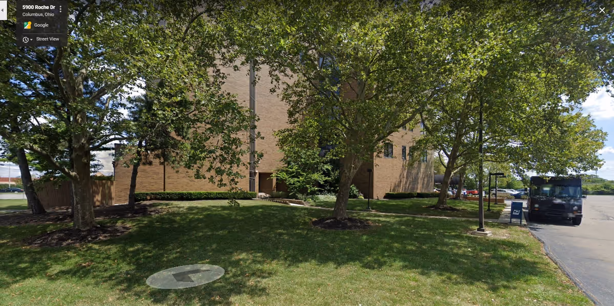 Exterior of Bono Home Health Care LLC building with green lawn, trees, and a parked bus.