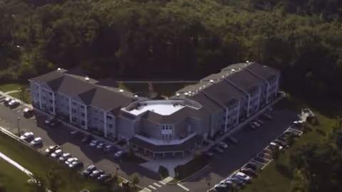 Aerial view of Waterfront Village senior living facility with multiple wings and surrounding parking.