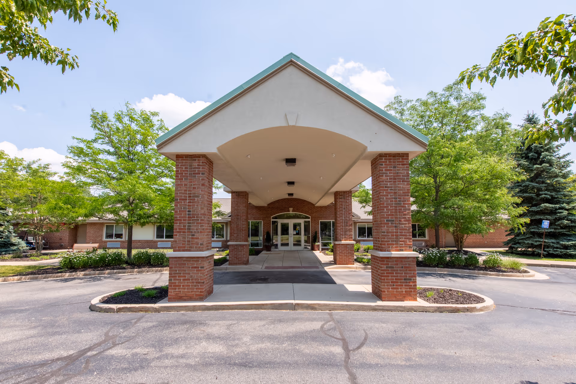 Brick entrance canopy supported by brick columns leads to the senior living facility's front doors.