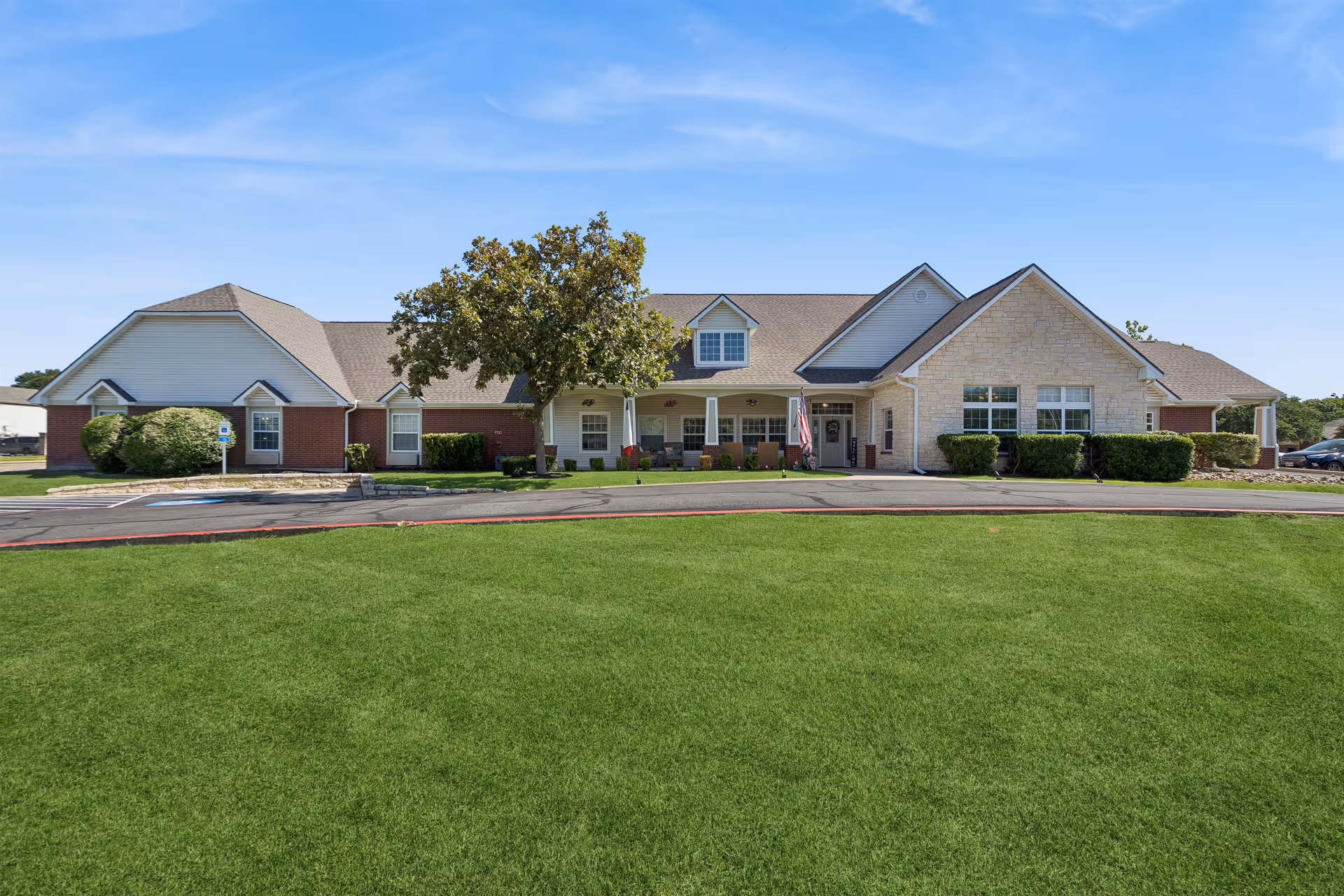 Front view of Brookdale Western Hills building with manicured lawn and blue sky.