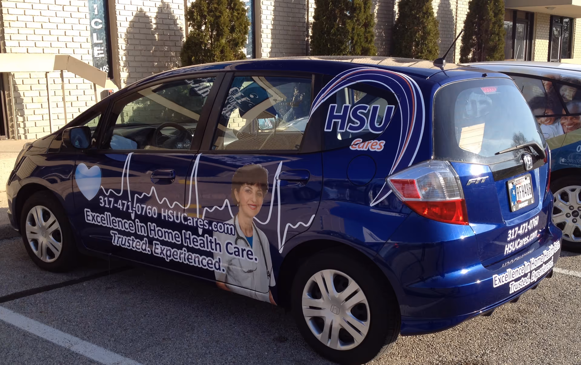 Blue Home Services Unlimited van with HSU cares graphics parked outside building.