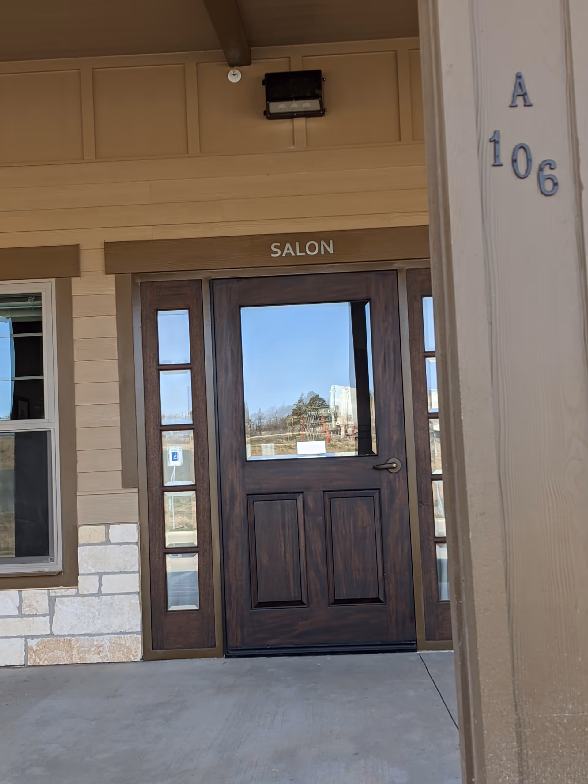 Exterior entrance to a senior living facility featuring a dark wooden door and glass sidelights.