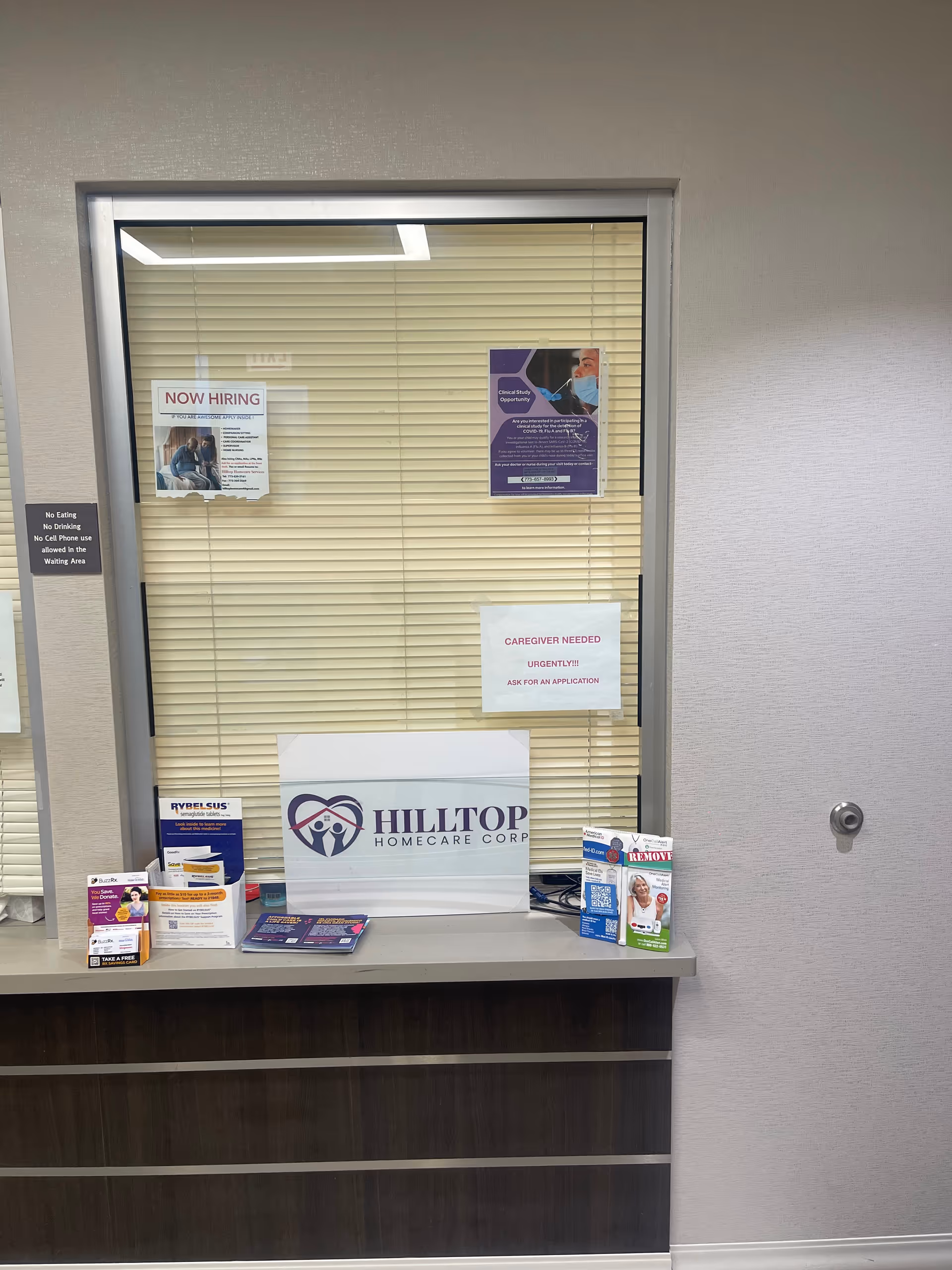 Reception desk inside with Hilltop Homecare Corp sign, posters, and brochures on display.