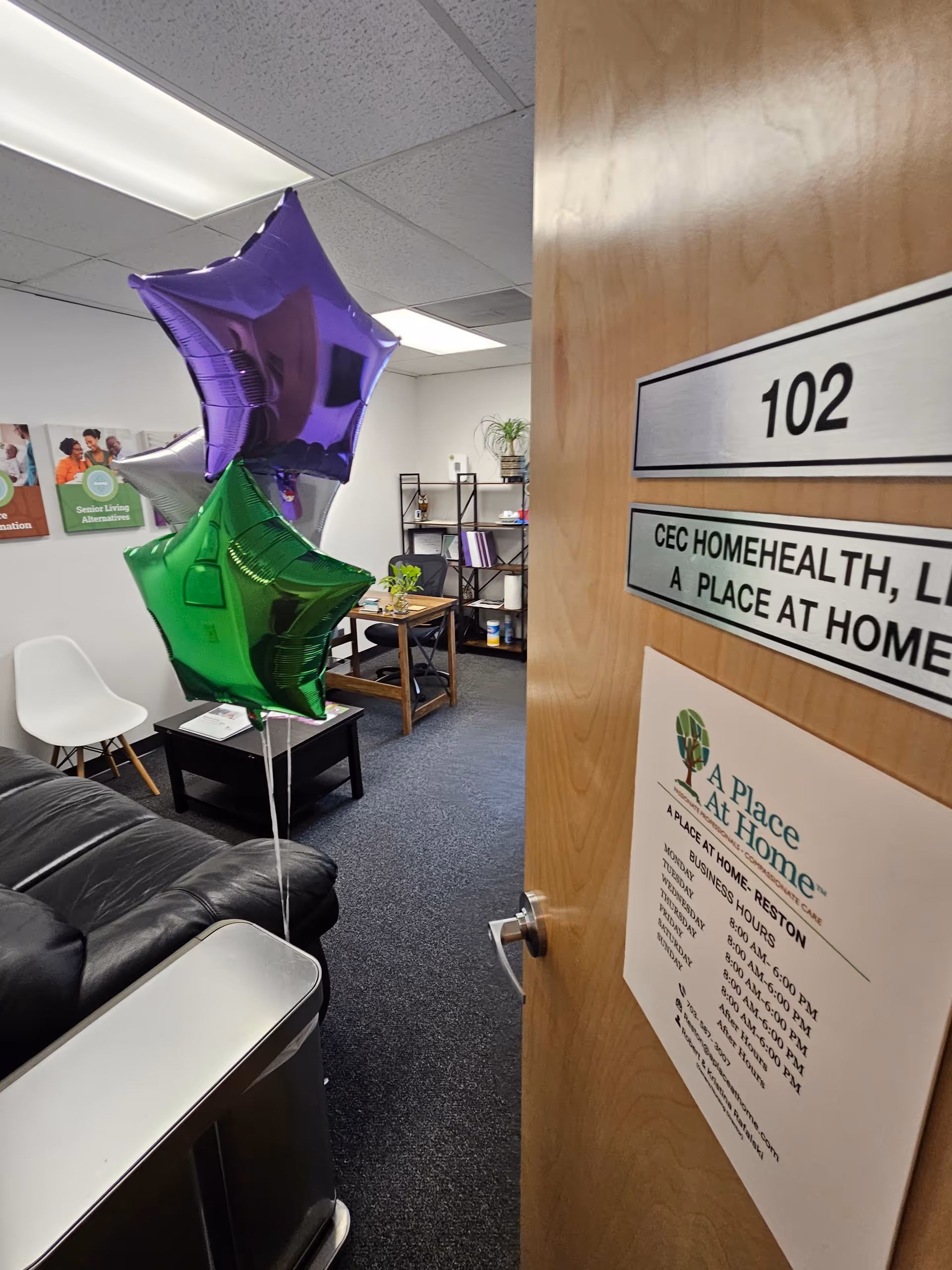 Interior waiting area of a care facility with balloons, furniture, and a doorway labeled 102.
