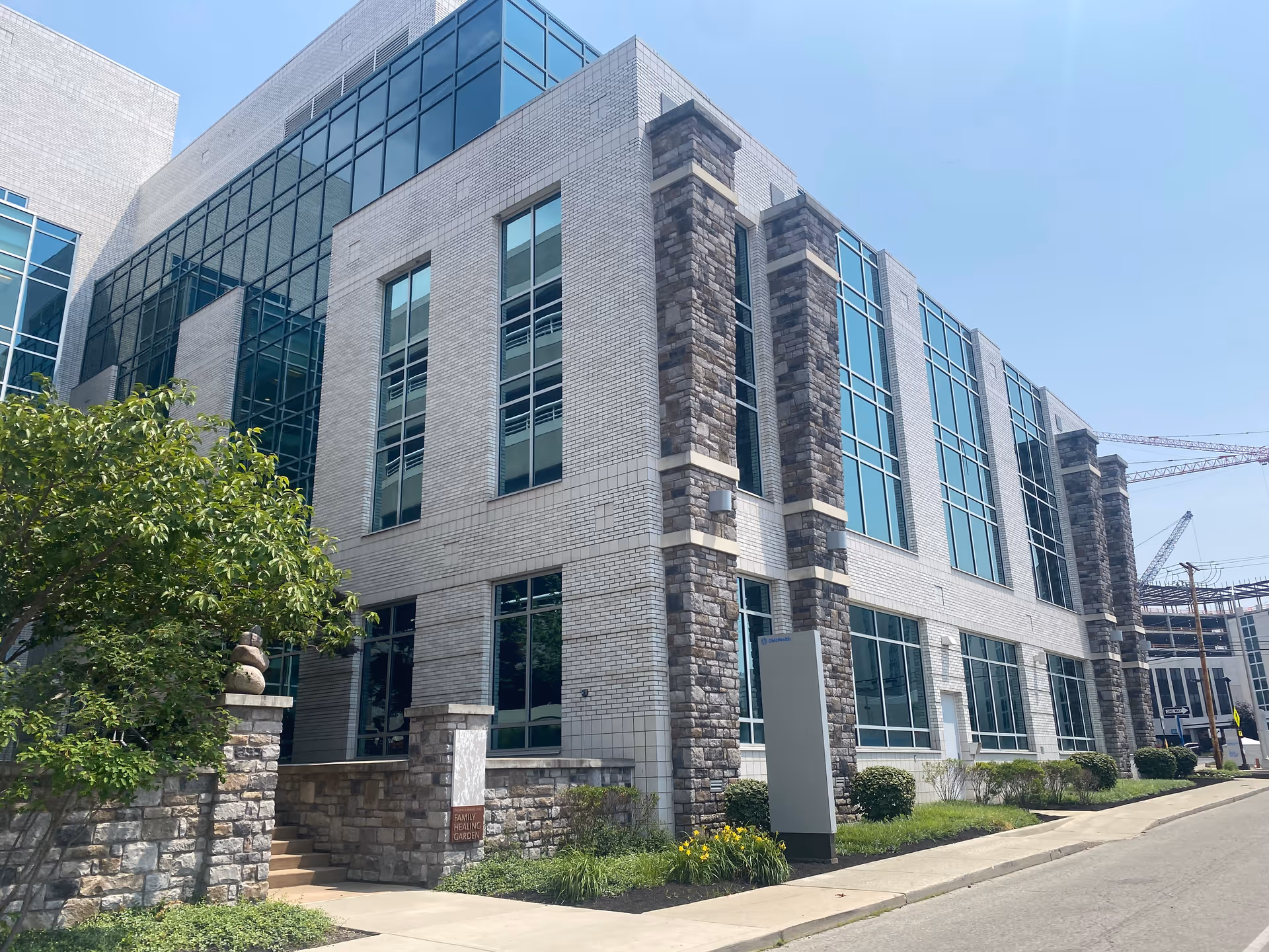 Exterior of a modern brick-and-glass medical building along a street.