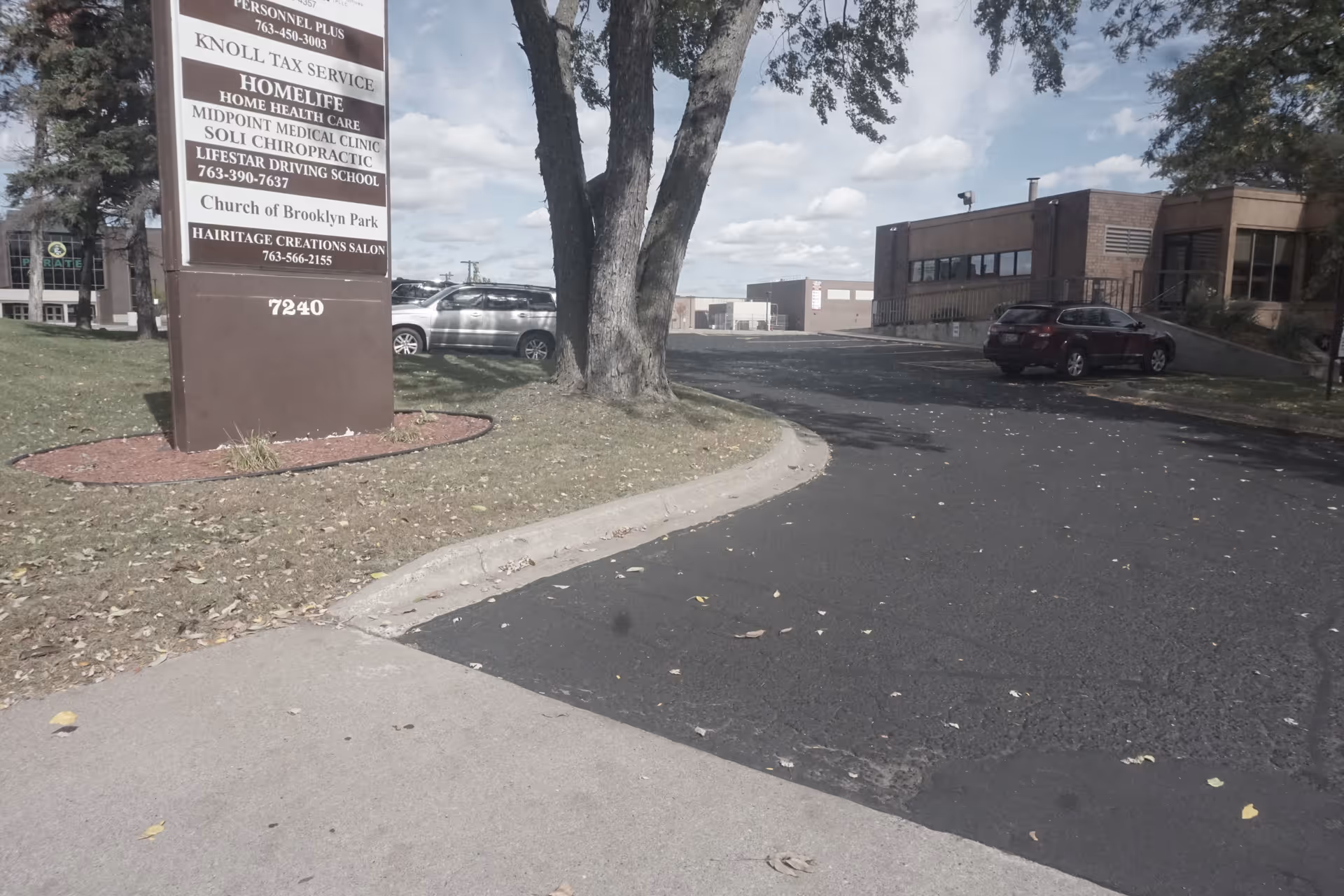 Exterior view of PrimeHealthMN facility with a tall sign and parking lot.