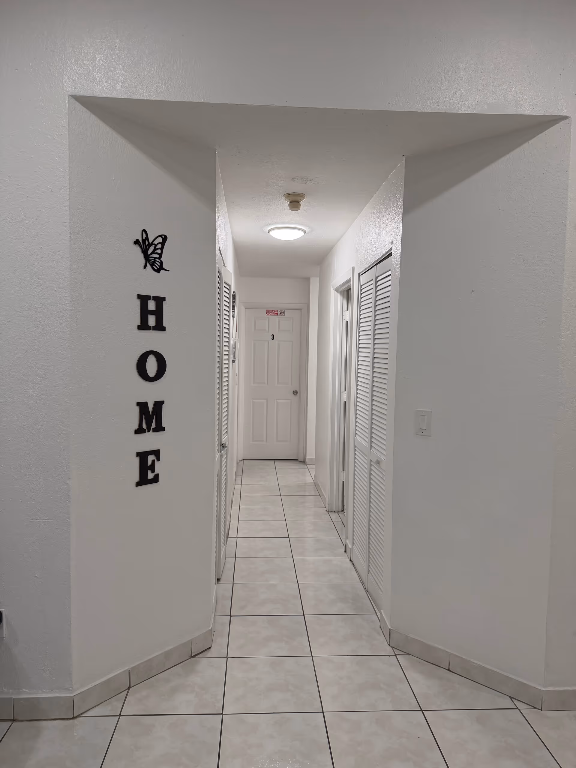Interior hallway of a Juan Pablo II senior living facility with 'HOME' decor.