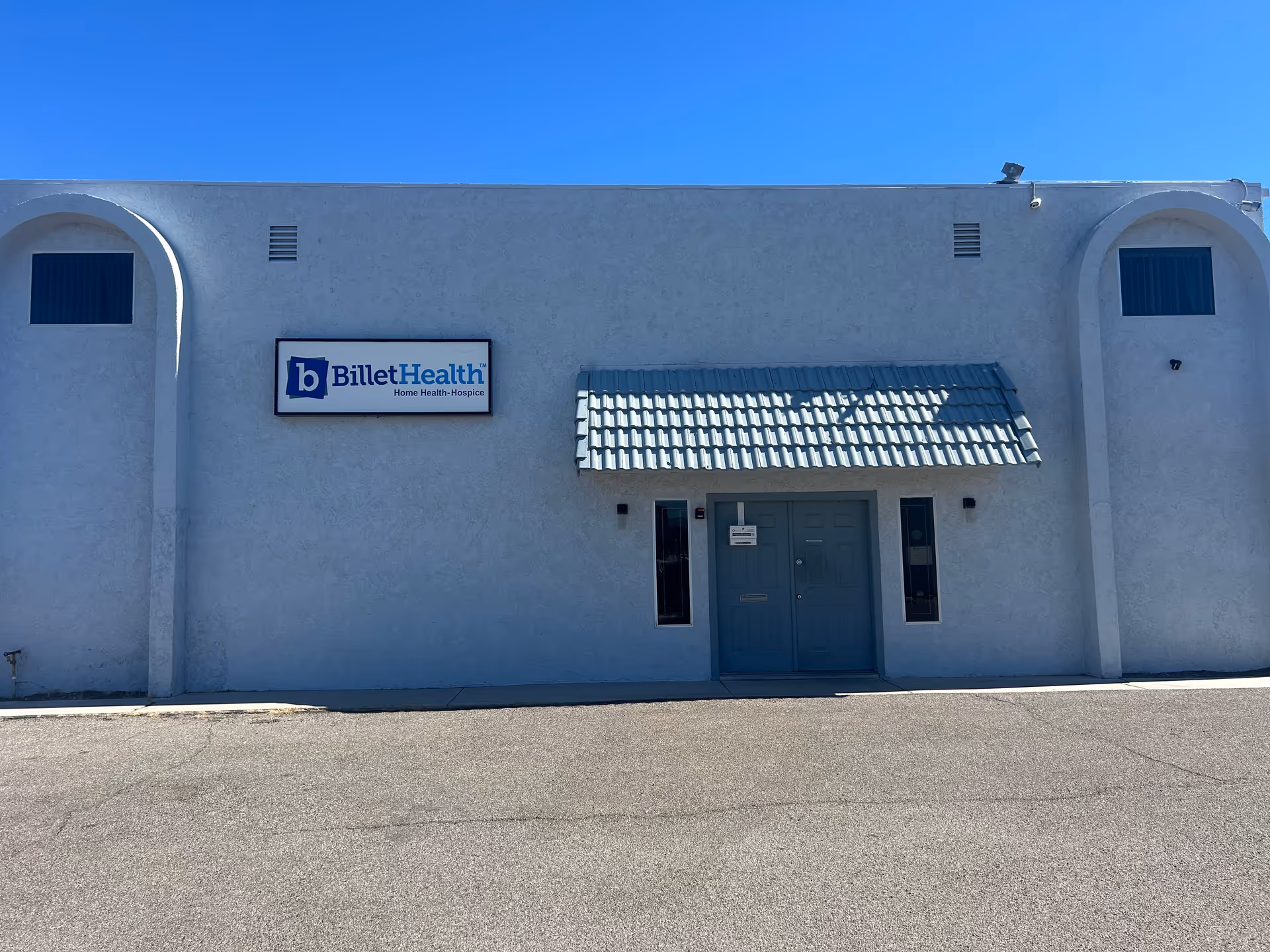 Blue gray facility building with Billet Health sign and central doors under a tiled awning.