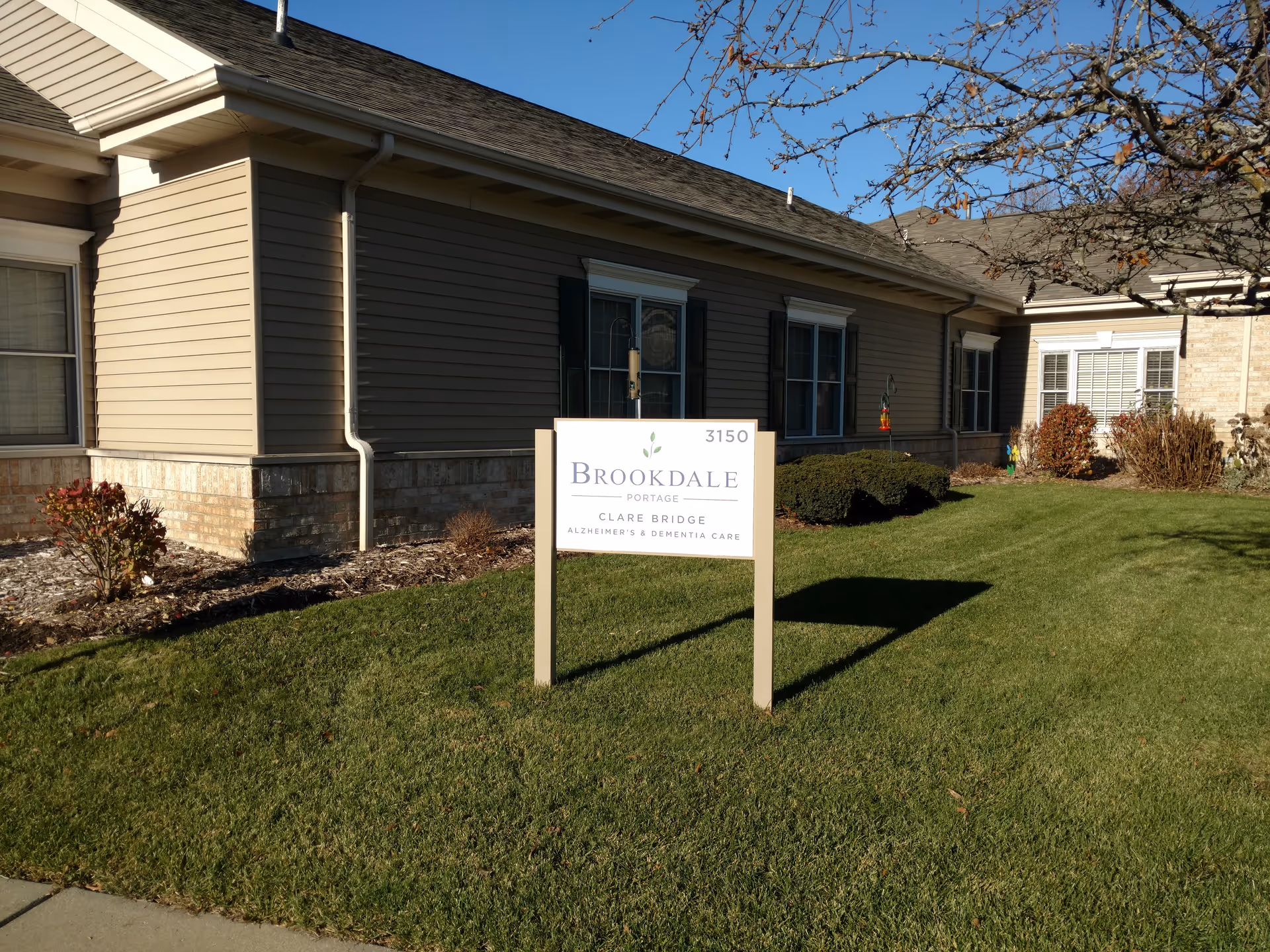 Front exterior of Brookdale Portage Memory Care with a sign on a grassy lawn.