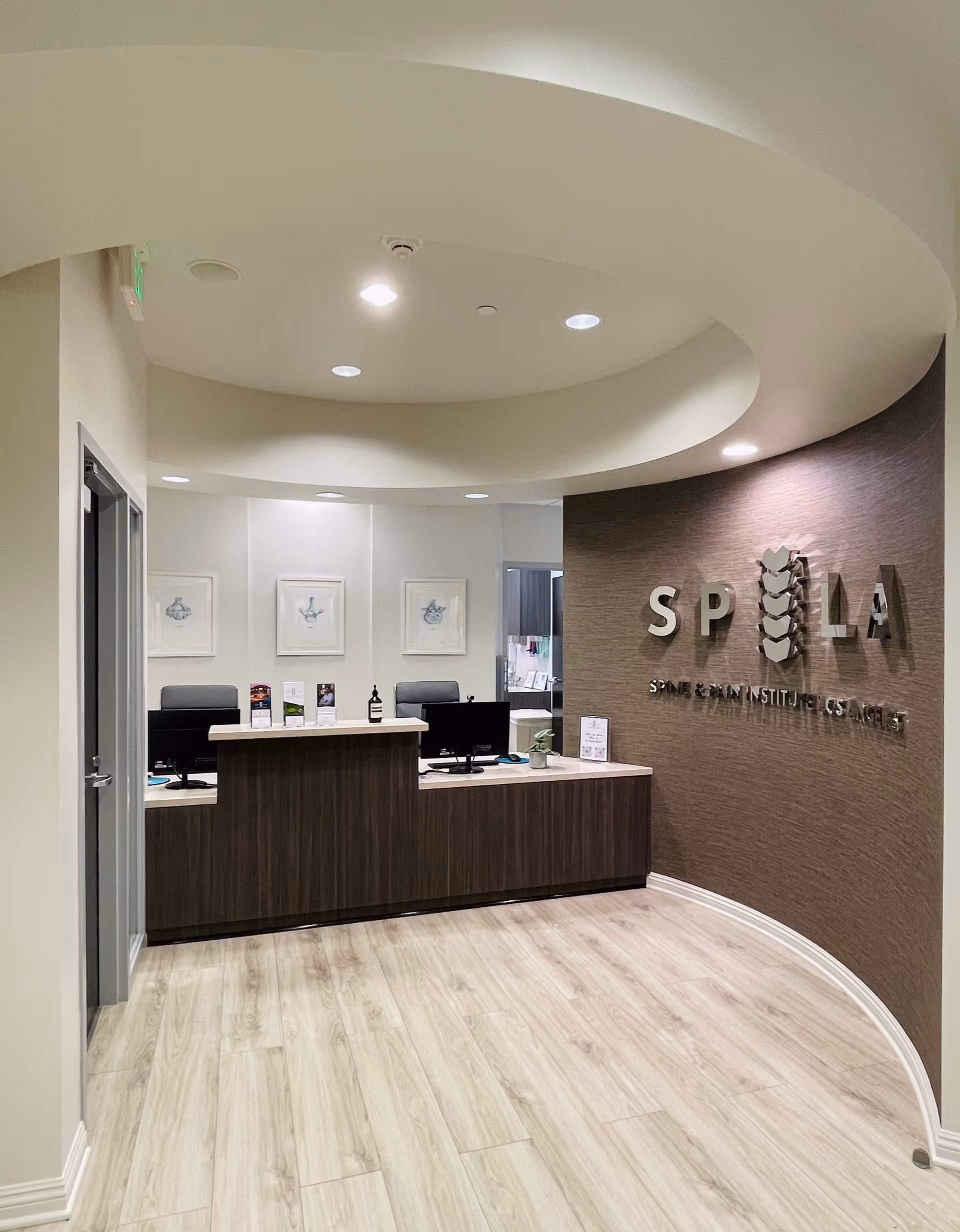 Interior reception area of Spine and Pain Institute Los Angeles with curved ceiling and front desk.