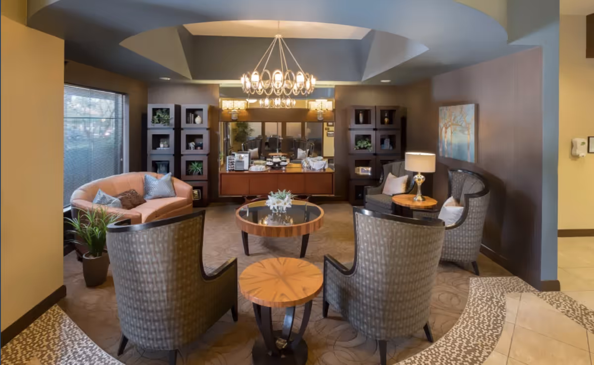 Luxurious interior lounge with circular seating, coffee tables, and a reception desk in the back.
