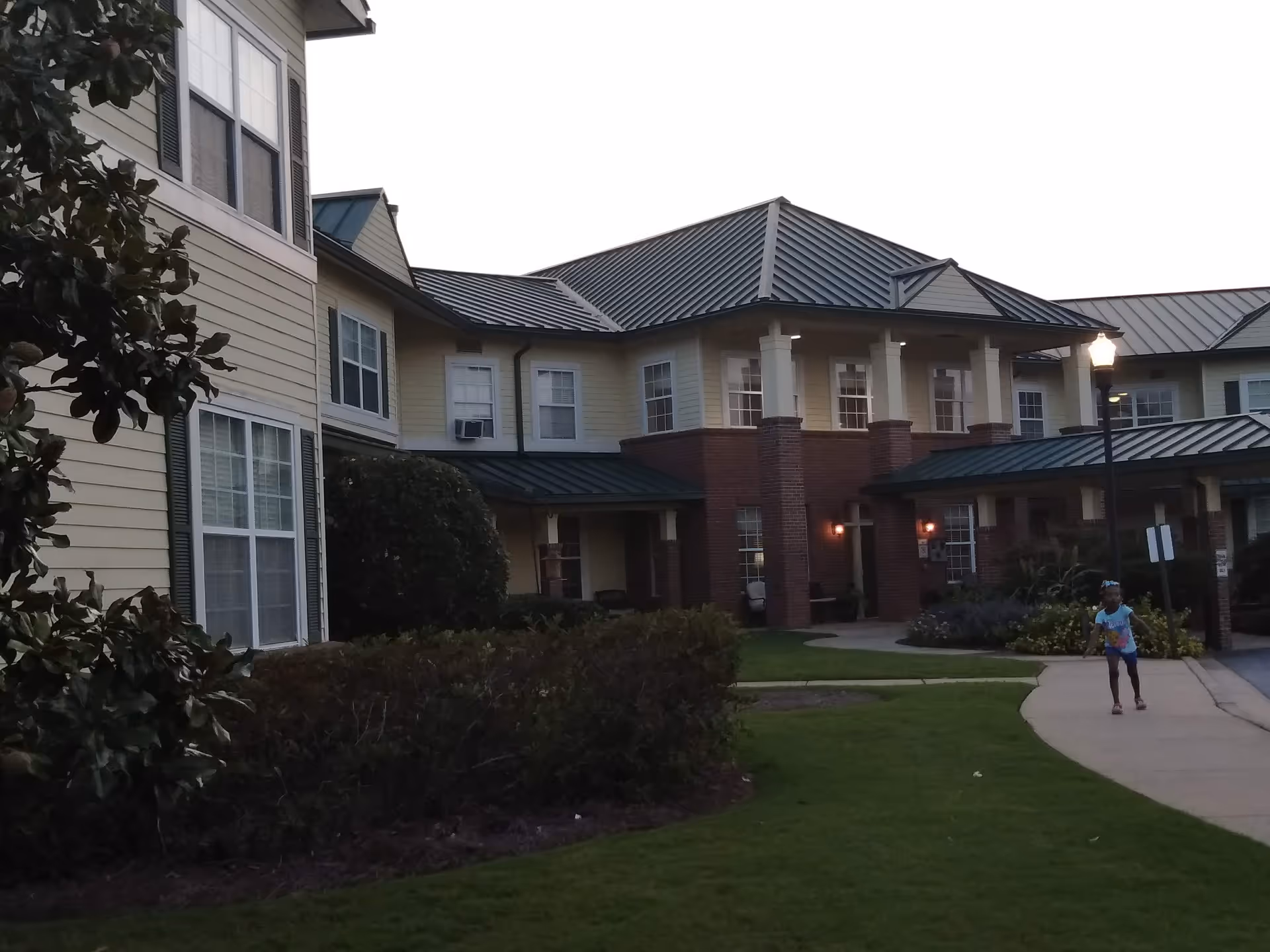 Exterior view of The Haven at Columbus building with lawn, walkway, and a person walking.