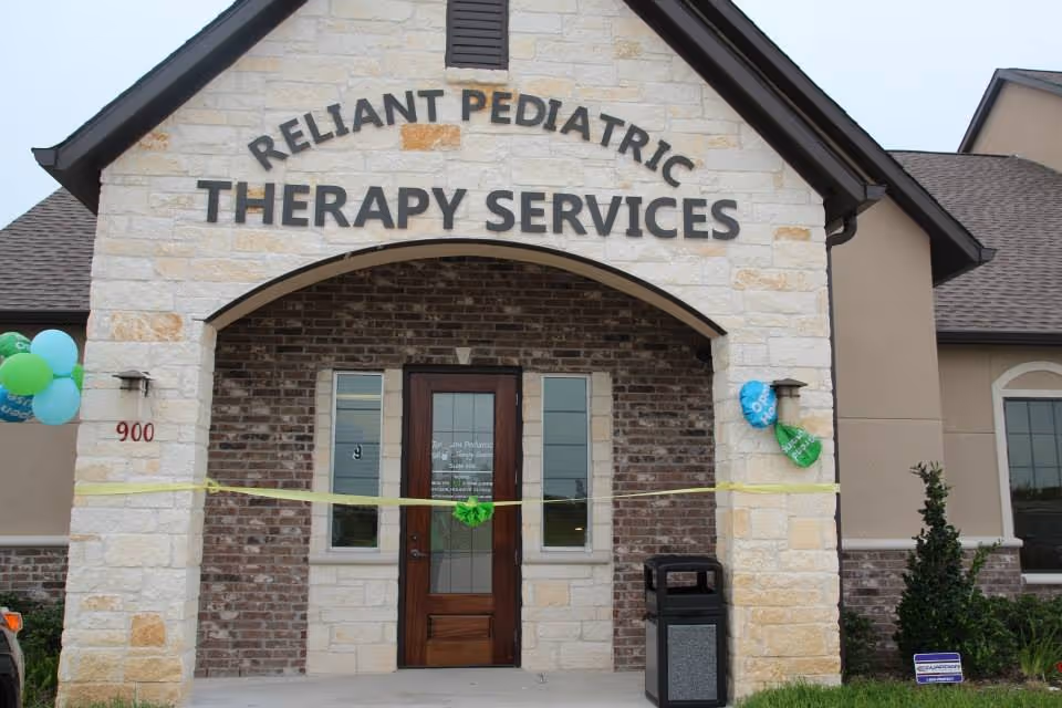 Front entrance of Reliant Pediatric Therapy Services building with stone facade and balloons.