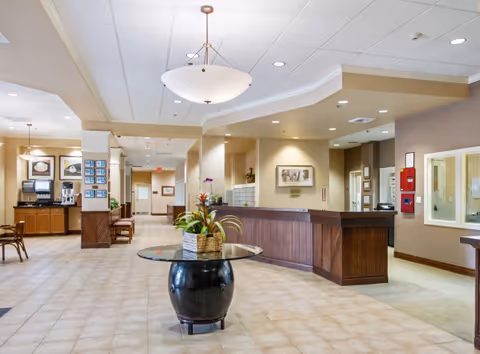 Lobby reception at The Plaza at Punchbowl featuring a curved front desk and round centerpiece table.